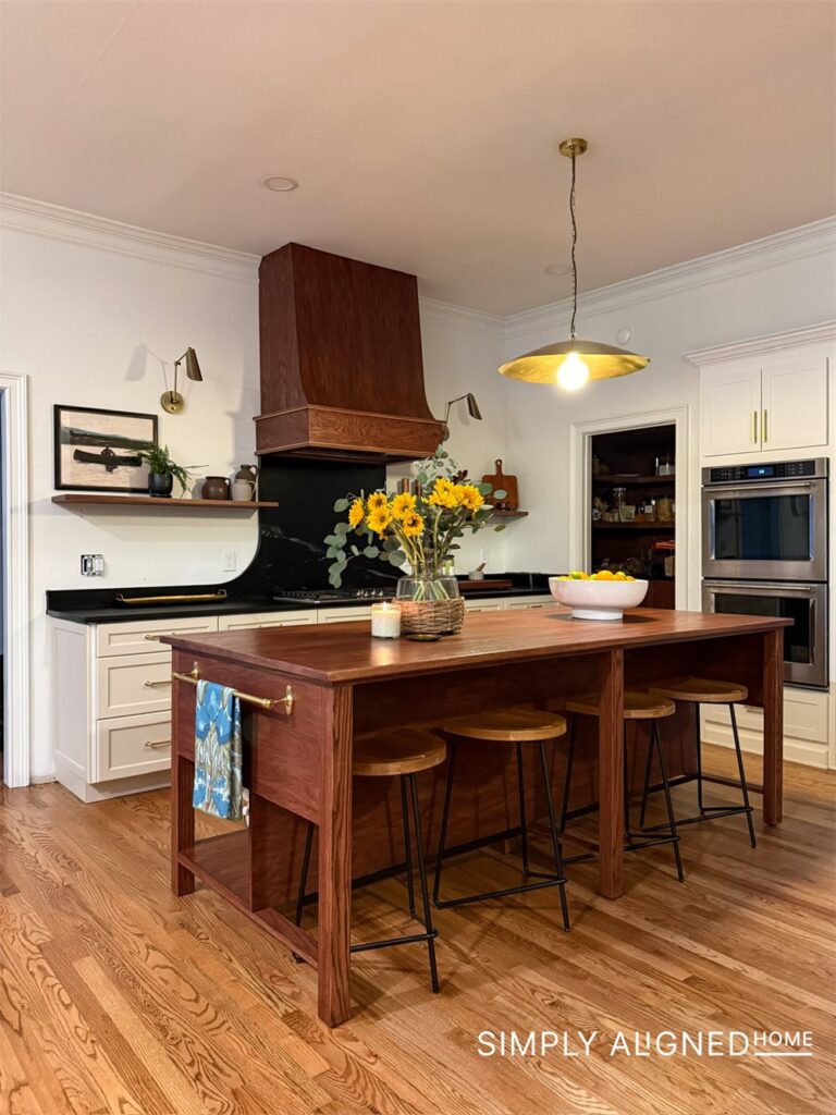 Red oak island, curved wood range hood and soapstone counters in a renovated kitchen