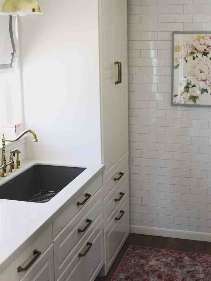 Small white condo kitchen with IKEA cabinets to the ceiling and subway tile