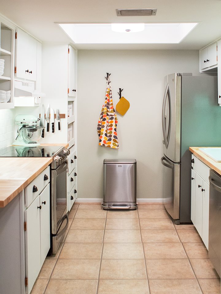 Small white galley kitchen with painted cabinets and white subway tile backsplash
